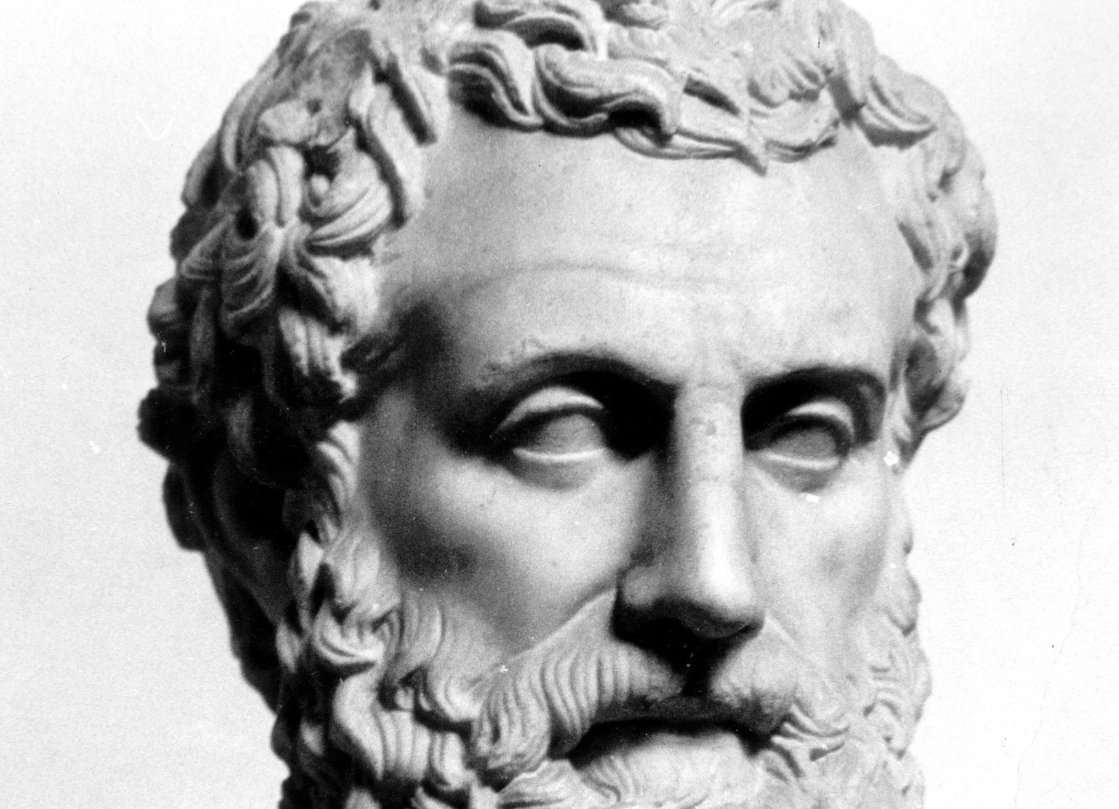 Marble bust of Aristotle, the ancient Greek philosopher, depicted with a contemplative expression and draped robe, sculpted in classical style.