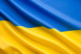 A blue and yellow Ukrainian flag ripples gently in the breeze, symbolizing heritage, resilience, and the ongoing journey of identity and belonging across time and place.