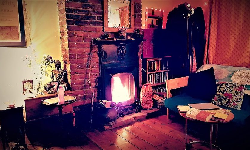 A fireplace alight in a bohemian room, in a cozy Lanes cottage in Brighton