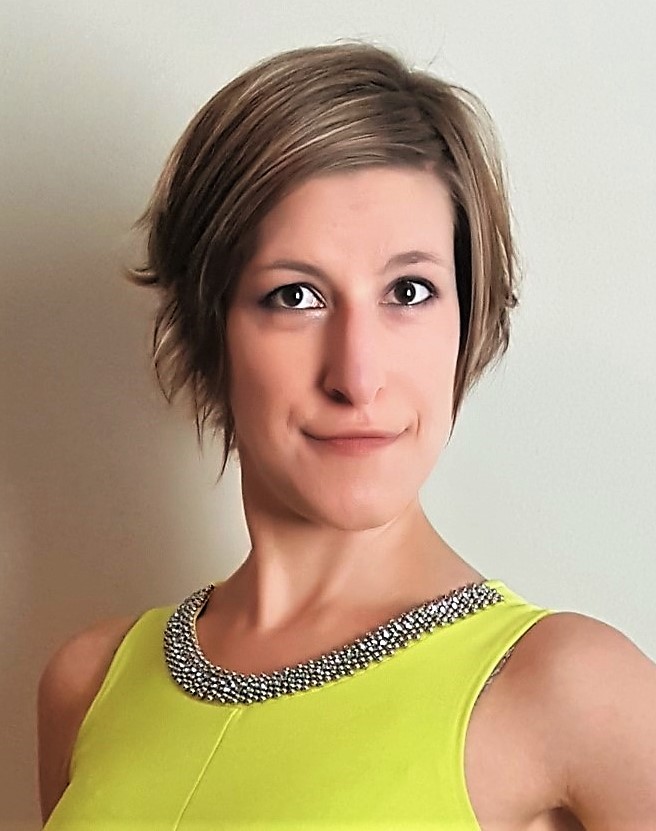Bust portrait of Teresa Stolarskyj in a sleeveless chartreuse dress with beaded neckline, with a slight, warm smile against a neutral background.
